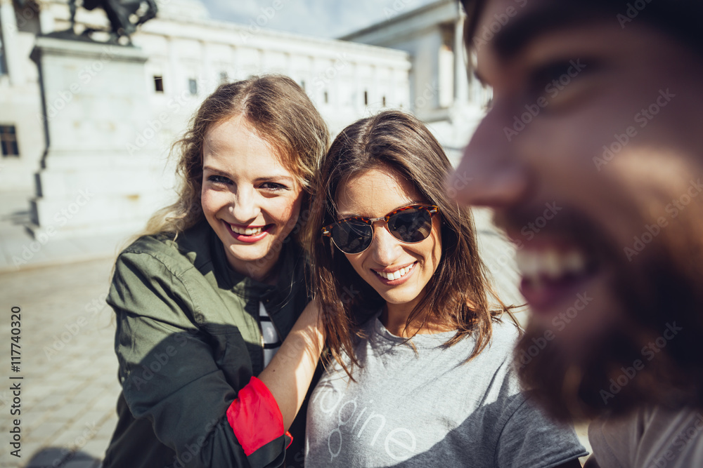 Austria, Vienna, three friends having fun in front of the parliament building Austria, Vienna, three friends having fun in front of the parliament building