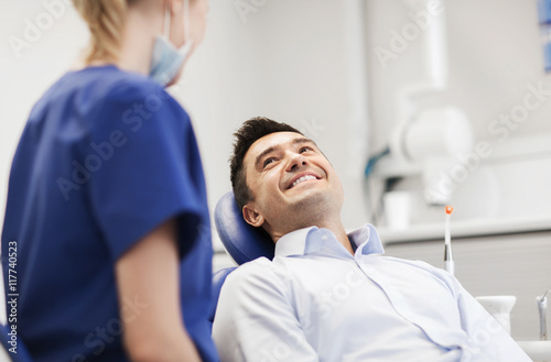 female dentist with happy male patient at clinic