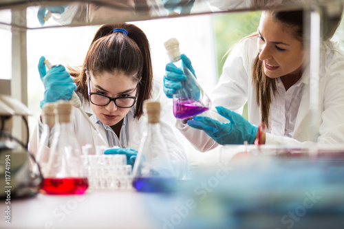 Two young female scientist doing experiments in lab.