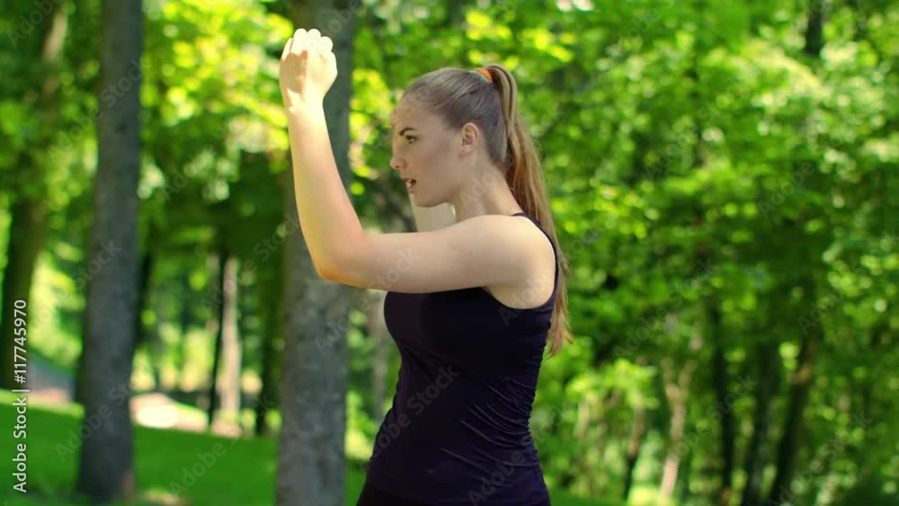 Woman doing fitness exercises in green park at spring. Closeup of female runner warm up muscles outdoor. Young woman stretching in park. Fit girl workout. Healthy lifestyle and wellness concept Woman doing fitness exercises in green park at spring. Closeup of female runner warm up muscles outdoor. Young woman stretching in park. Fit girl workout. Healthy lifestyle and wellness concept