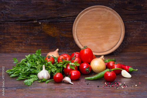 empty wooden plate on background vegetables on a wooden table