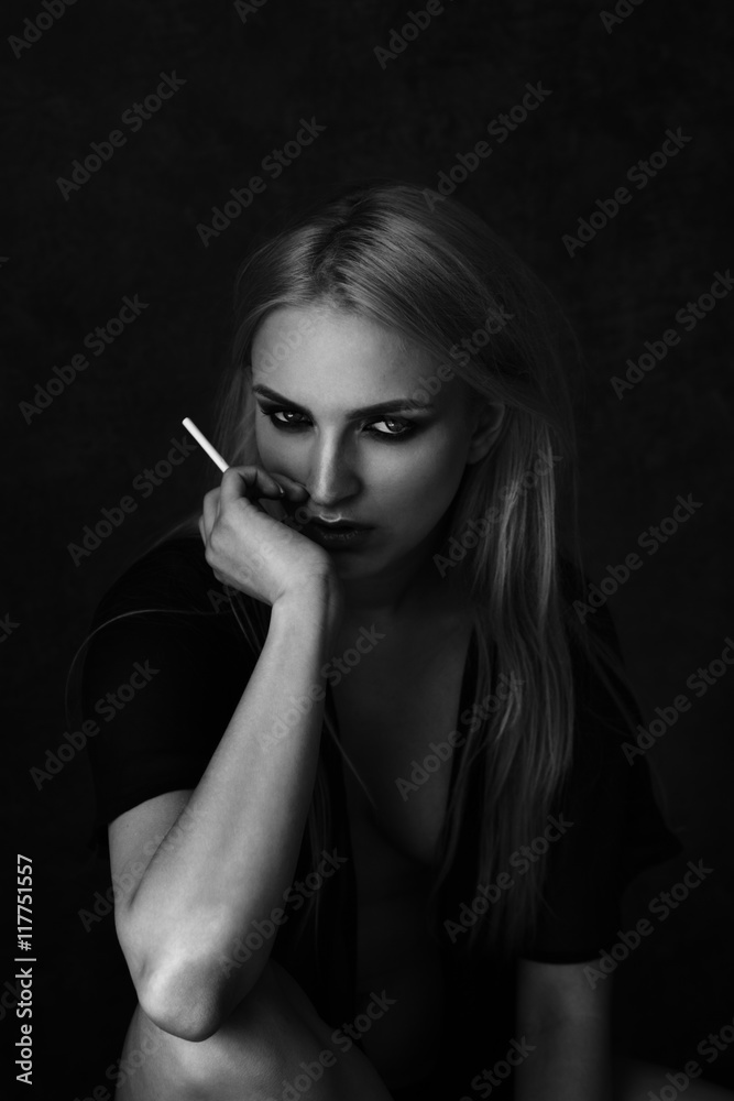 Obraz premium Sexy woman with smoky eyes makeup smoking