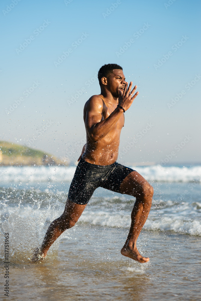 Fit black man running by the sea splashing watter. Black runner ...