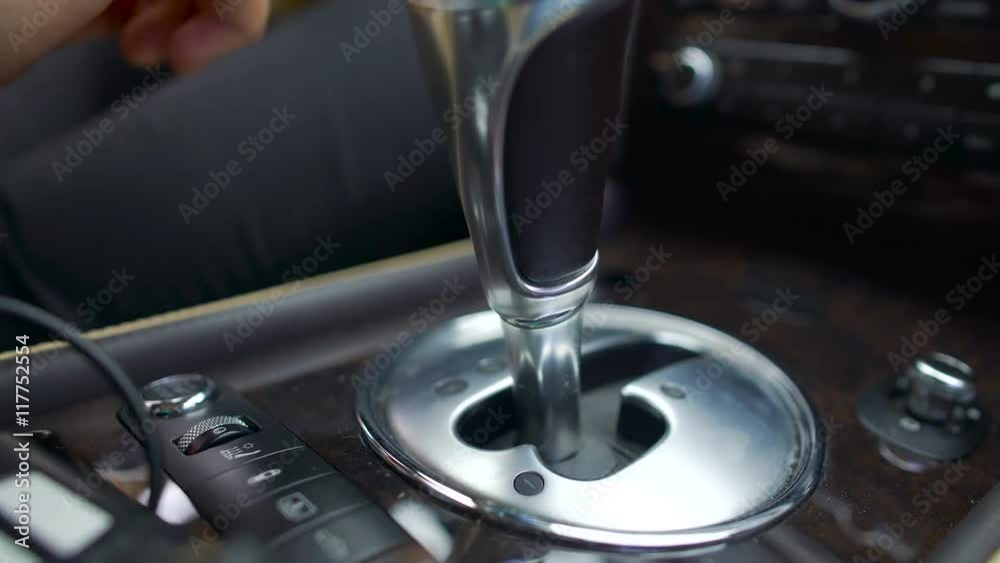 Close-up of male hands switching automatic gearbox in expensive car, driver Close-up of male hands switching automatic gearbox in expensive car, driver