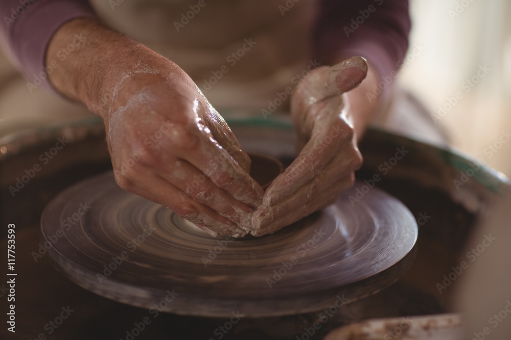 Male potter making bowl