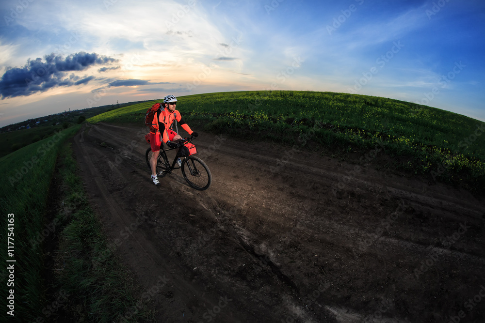 Fototapeta premium Mountain bikeer rides on the trail against beautiful sunset