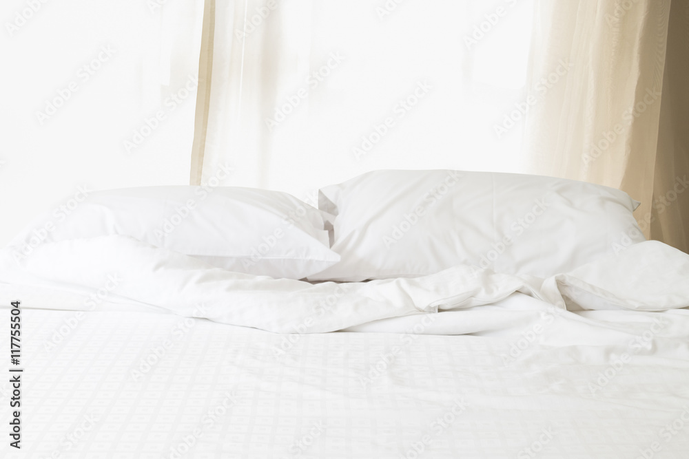 Messy white bed with pillow and blanket morning sunlight through Messy white bed with pillow and blanket morning sunlight through