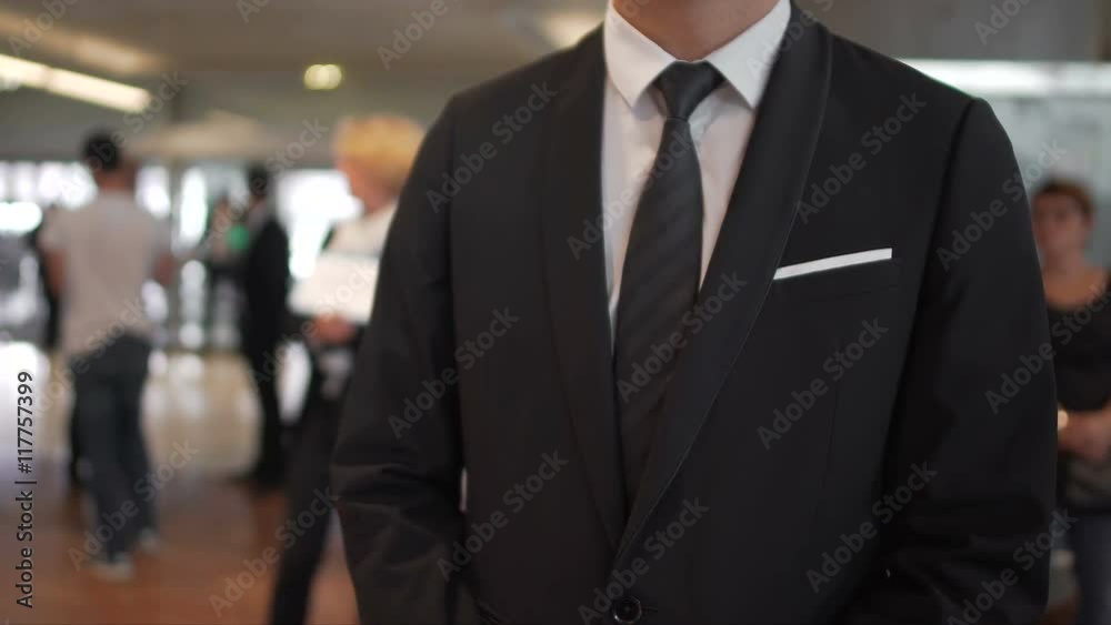 Man in business suit waiting for arrivals in airport hall, travel agent, tourism Man in business suit waiting for arrivals in airport hall, travel agent, tourism