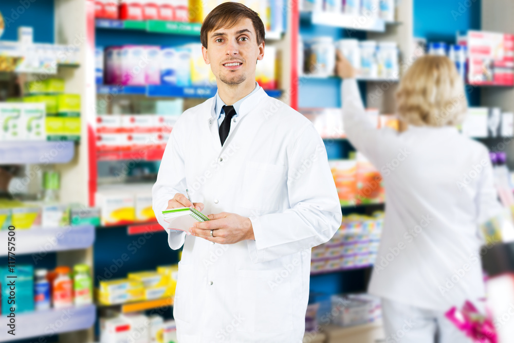Pharmacist and pharmacy technician posing in drugstore