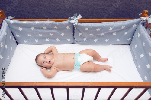 Infant baby laying in decorated cot