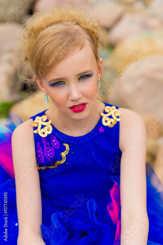 portrait of a beautiful cute girl with makeup in a blue dress