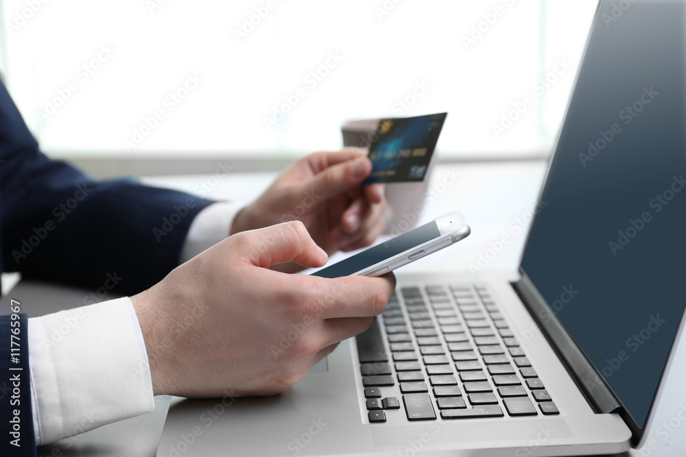 Businessman working with credit card and laptop in office Businessman working with credit card and laptop in office