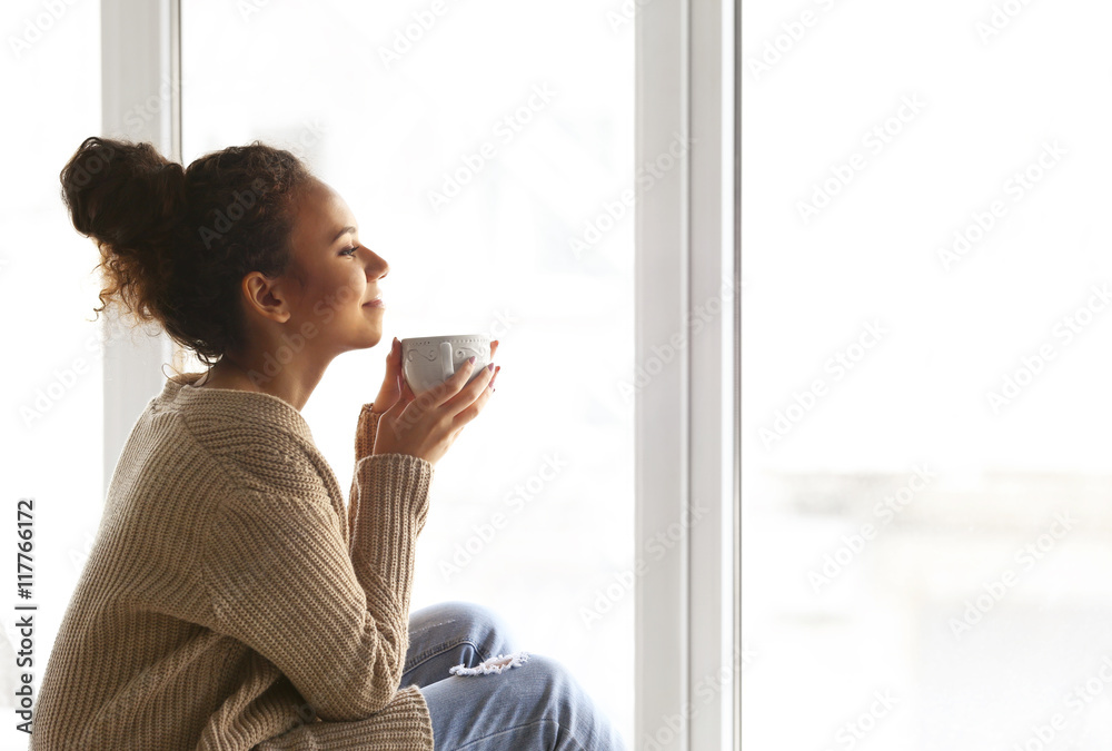 Beautiful African American girl drinking coffee at home Beautiful African American girl drinking coffee at home
