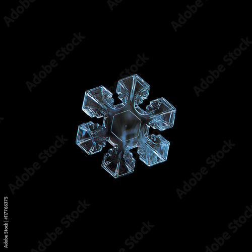 Snowflake isolated on black background. This is macro photo of real snow crystal with six short, broad arms and good symmetry.