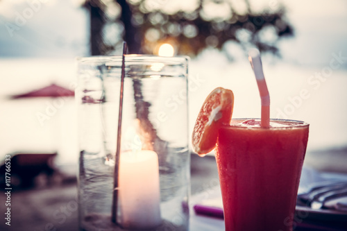 blured beach holidays  background with cocktail and candle in glass  at sunset beach caffe photo