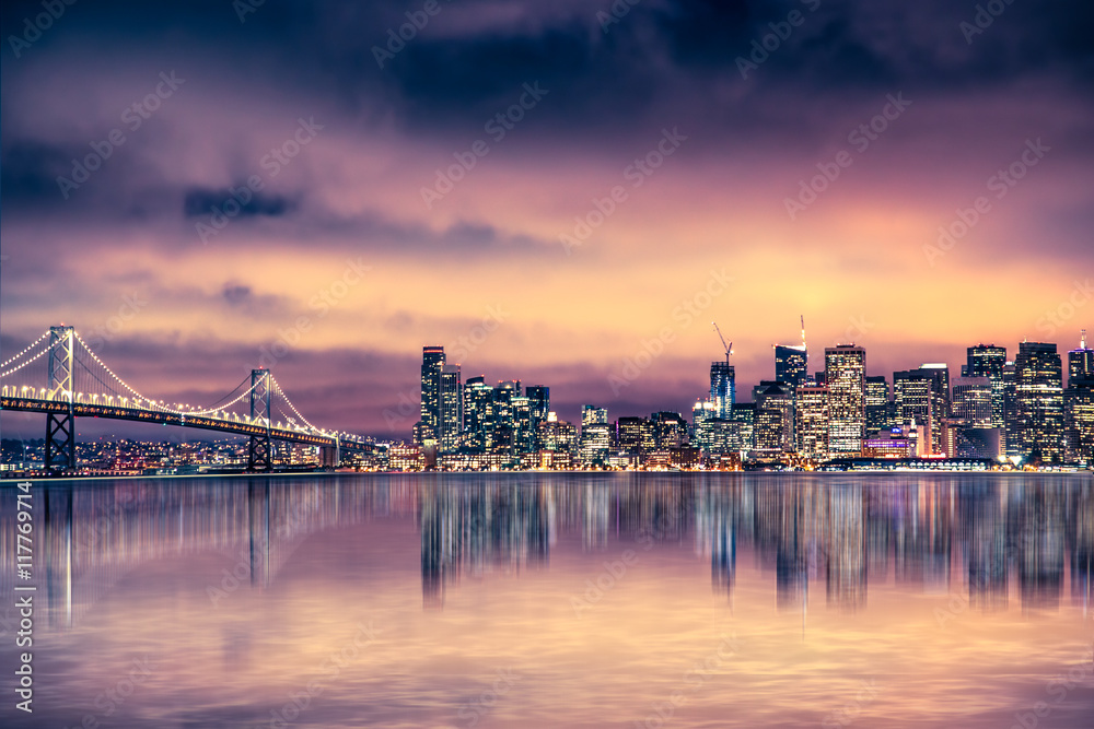 San Francisco California skyline with lights and bay under colorful sunset sky - obrazy, fototapety, plakaty 