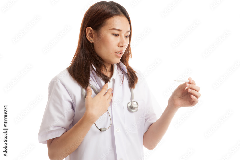 Young Asian female doctor worry look at thermometer. Young Asian female doctor worry look at thermometer.