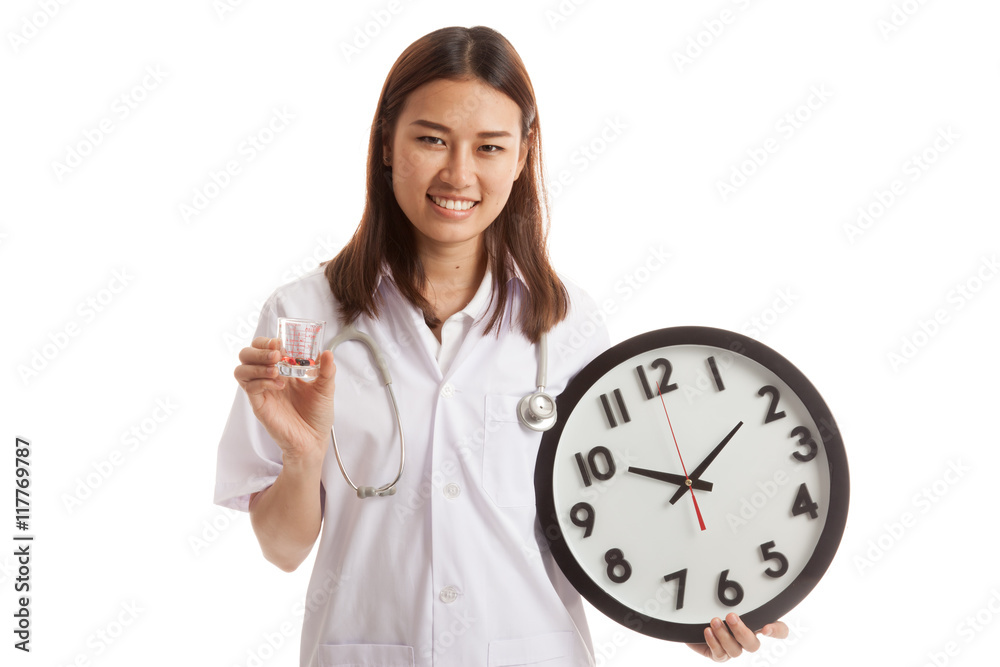 Young Asian female doctor smile with a clock and pills in hand. Young Asian female doctor smile with a clock and pills in hand.