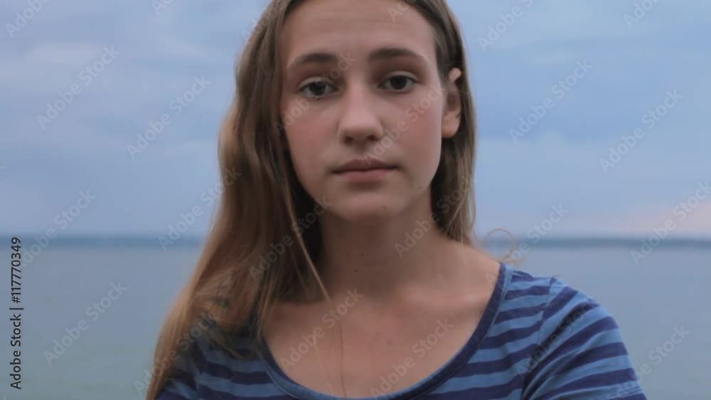 Loneliness sad teenager girl beach sea. Portrait of depressed woman, zoom out Loneliness sad teenager girl beach sea. Portrait of depressed woman, zoom out