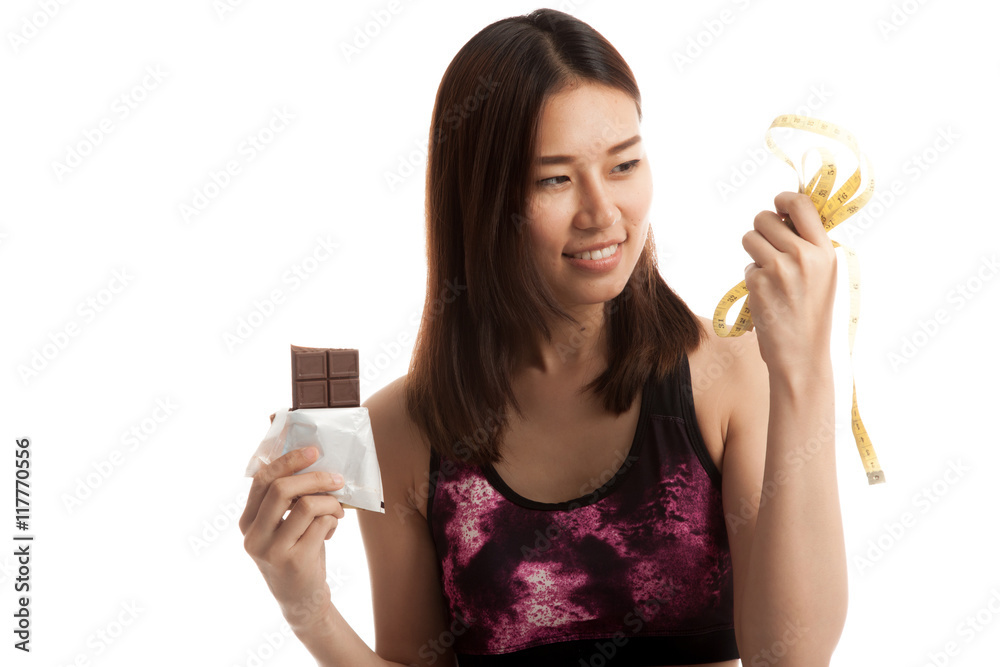 Beautiful Asian healthy girl with chocolate and measuring tape. Beautiful Asian healthy girl with chocolate and measuring tape.