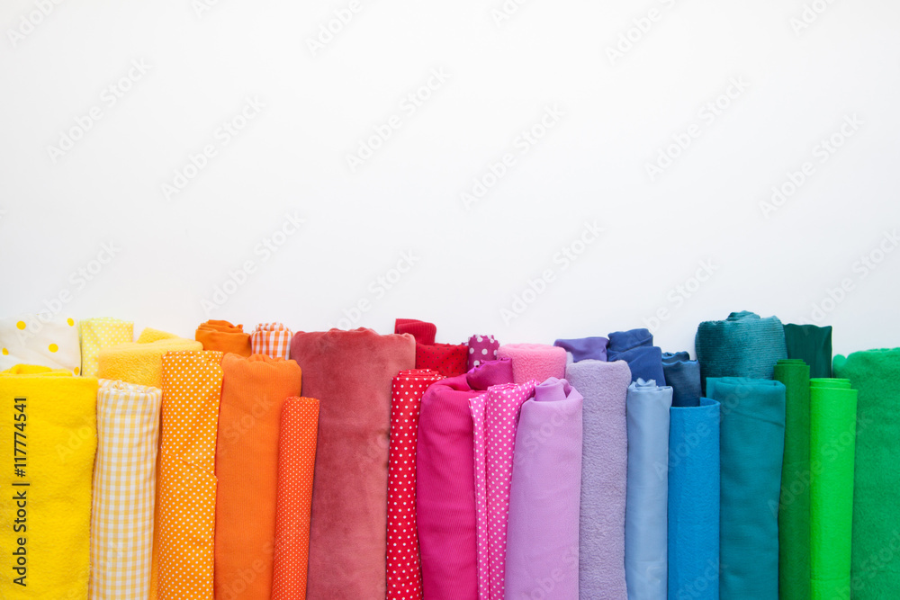 Rolls of bright colored fabric on a white background. - obrazy, fototapety, plakaty 