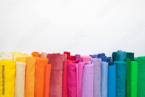 Rolls of bright colored fabric on a white background.