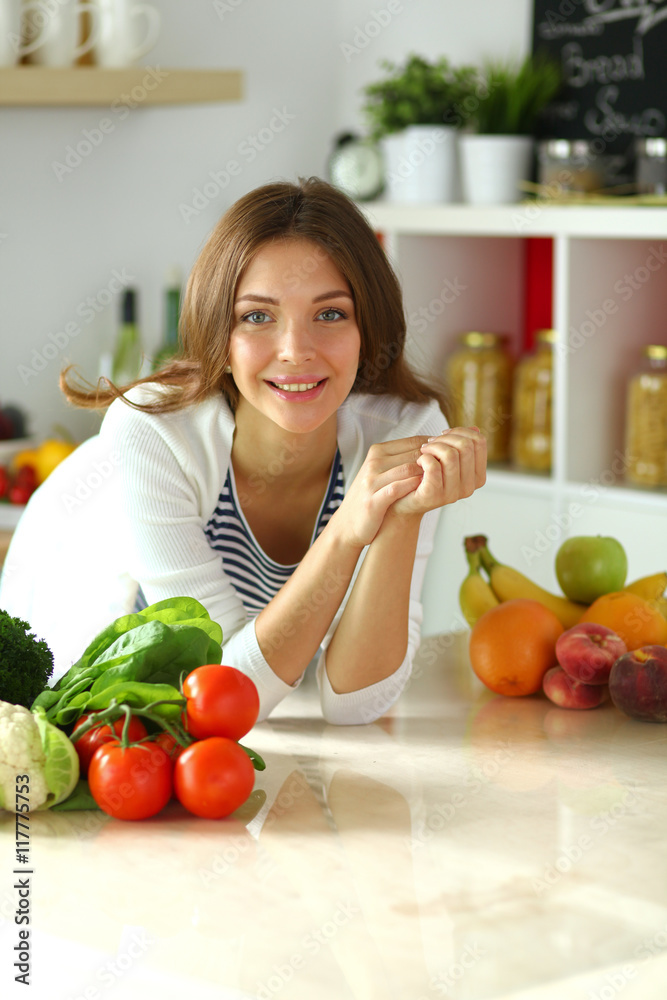Young woman sitting near desk in the kitchen Young woman sitting near desk in the kitchen
