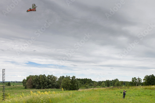 Boy launches kite on meadow