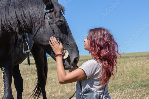 Beautiful girl and black horse in nature. Kiev, Ukraine