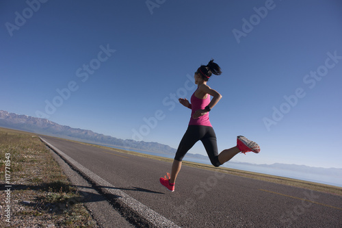  young fitness woman runner running on sunrise seaside trail