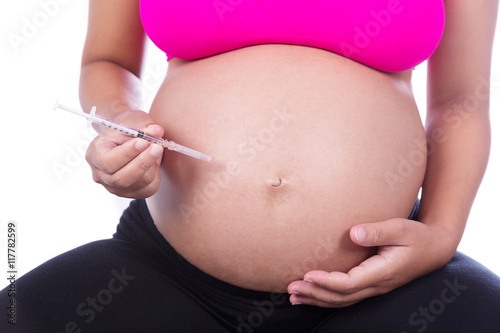Pregnant woman with syringe on white background