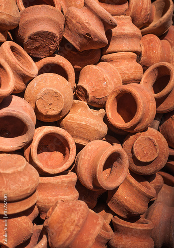 A pile of handmade clay terracotta pots on sale at a street market in India.