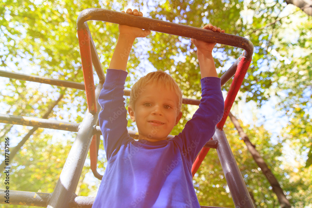 Fototapeta premium little boy playing on monkey bars, kids sport