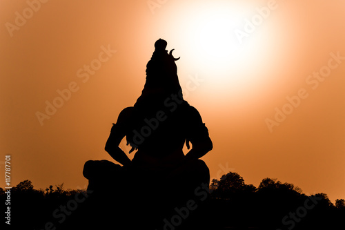 Fotografie, Obraz A silhouette of a statue of the Hindu god Shiva on the banks of the Ganges at Rishikesh in North India