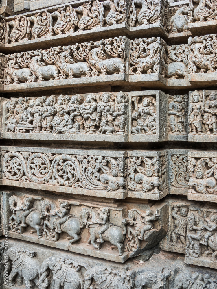 A wall covered in sculpted figures symbolizing different historical events at the 13th Century temple of Somanathapur, Karnataka, South India.