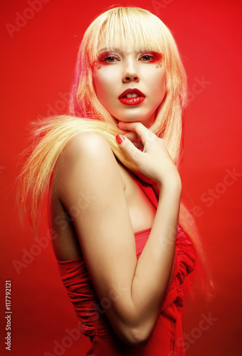 Perfect blond model in red dress over red background.