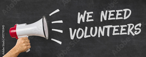 A man holding a megaphone - We need volunteers