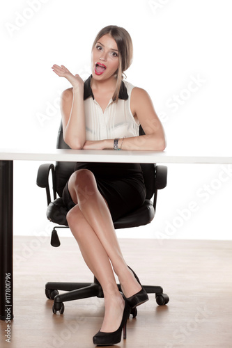 Happy young business woman sitting on empty desk