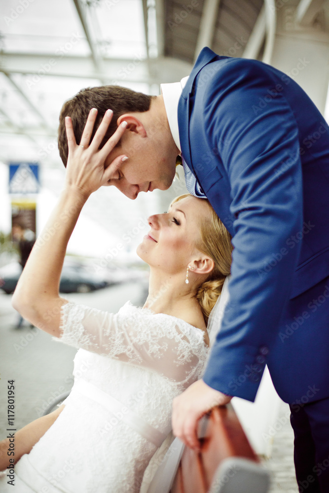 Bride holds her palm over groom's head while he stands over her Bride holds her palm over groom's head while he stands over her