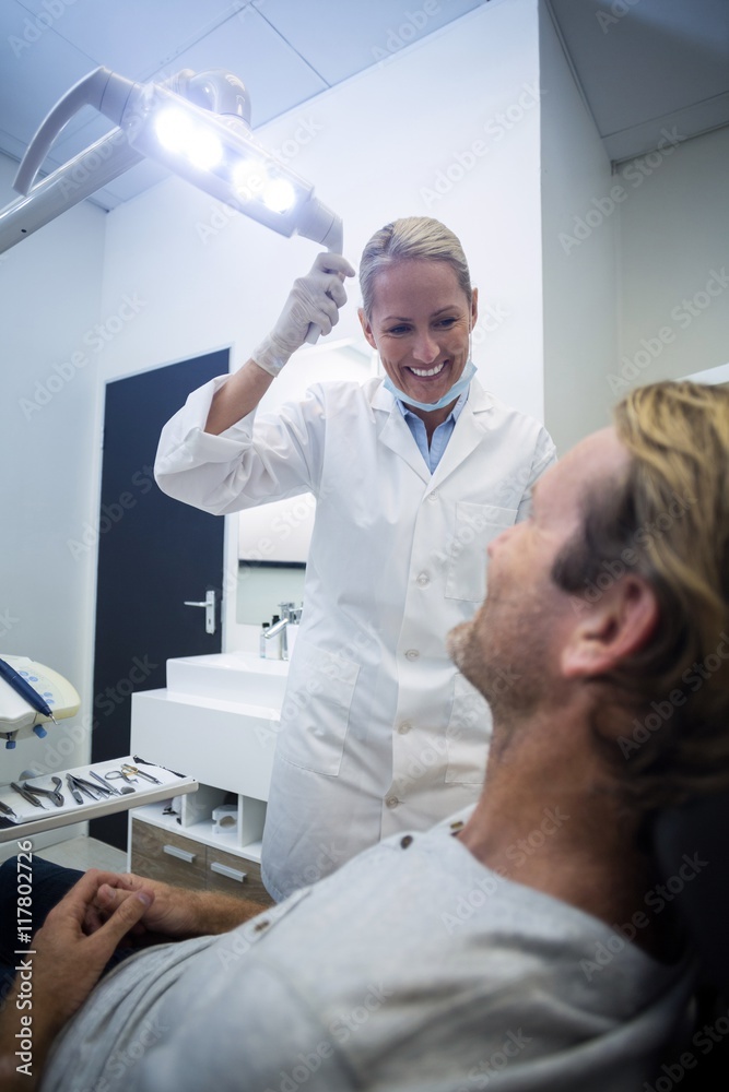 Female dentist interacting with male patient Female dentist interacting with male patient