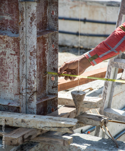 Принти на полотні worker using a plumb bob for check pillar
