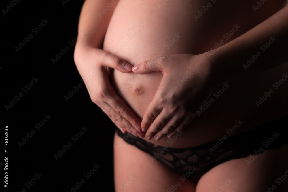 Closeup of pregnant woman make hands heart shape