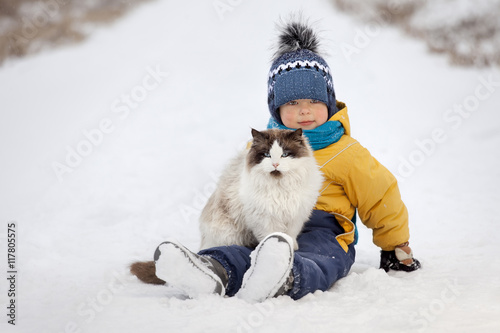 boy plays with a cat outdoors