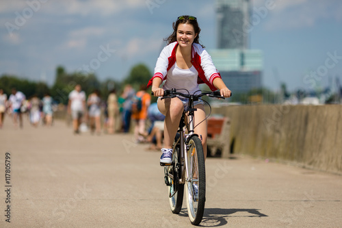 Urban biking - young woman and bike in city 