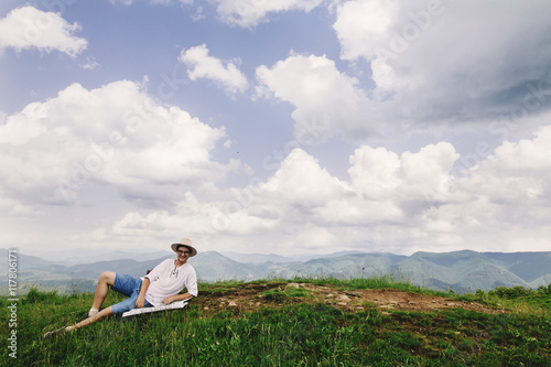 hipster traveler sitting at top of mountains with amazing view a