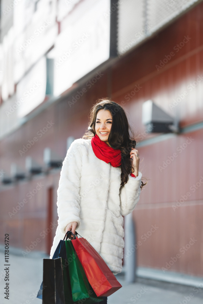 Nice girl standing with colorful shopping bags