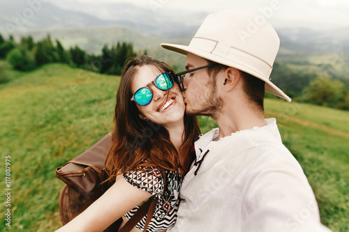 stylish hipster couple traveling and kissing and laughing on t