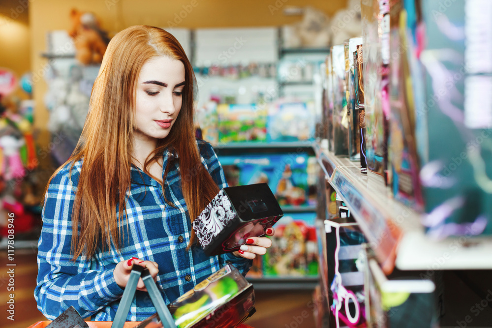 Fototapeta premium Beautiful girl with long brown hair shopping at store