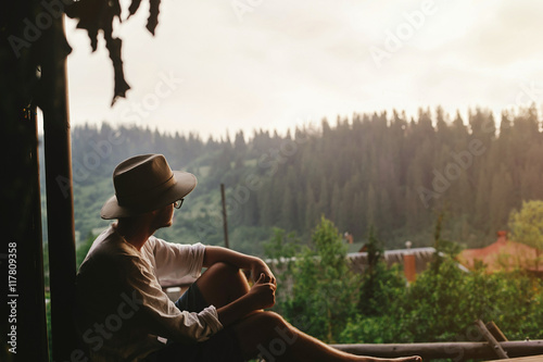 Cuadro en lienzo hipster man sitting on porch of wooden house  looking at woods i