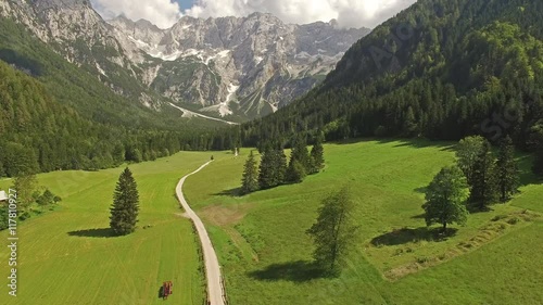 Camera flying above road pathway to the mountains with breath taking view